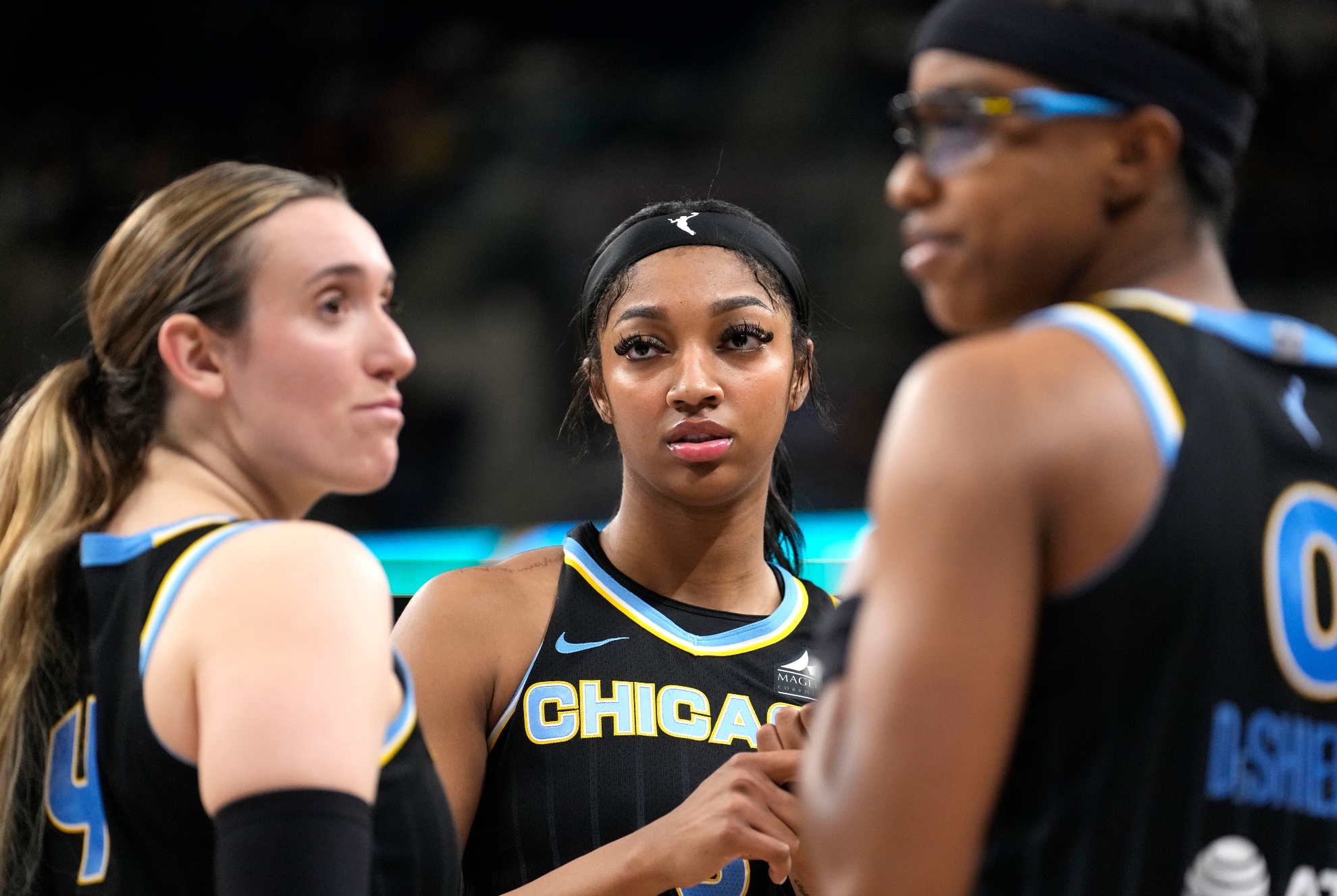 Chicago Skys Angel Reese, center, listens to Marina Mabrey, left, with Diamond DeShields during a WNBA basketball game against the Connecticut Sun Wednesday, June 12, 2024, in Chicago.