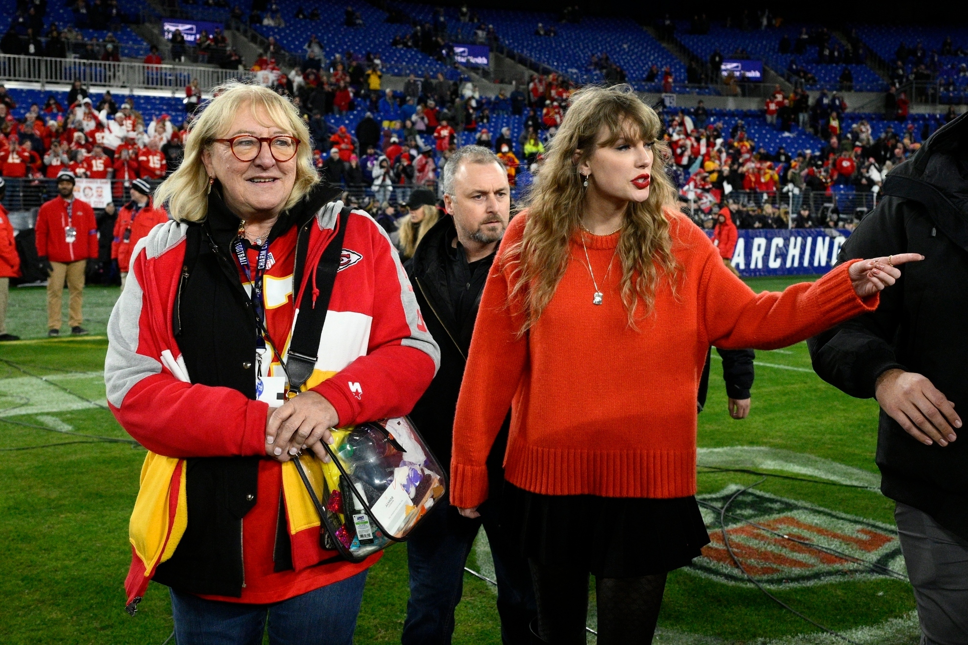 Taylor Swift, right, walks with Donna Kelce on the field after the AFC Championship NFL football game between the Baltimore Ravens and the Kansas City Chiefs, Sunday, Jan. 28, 2024, in Baltimore.