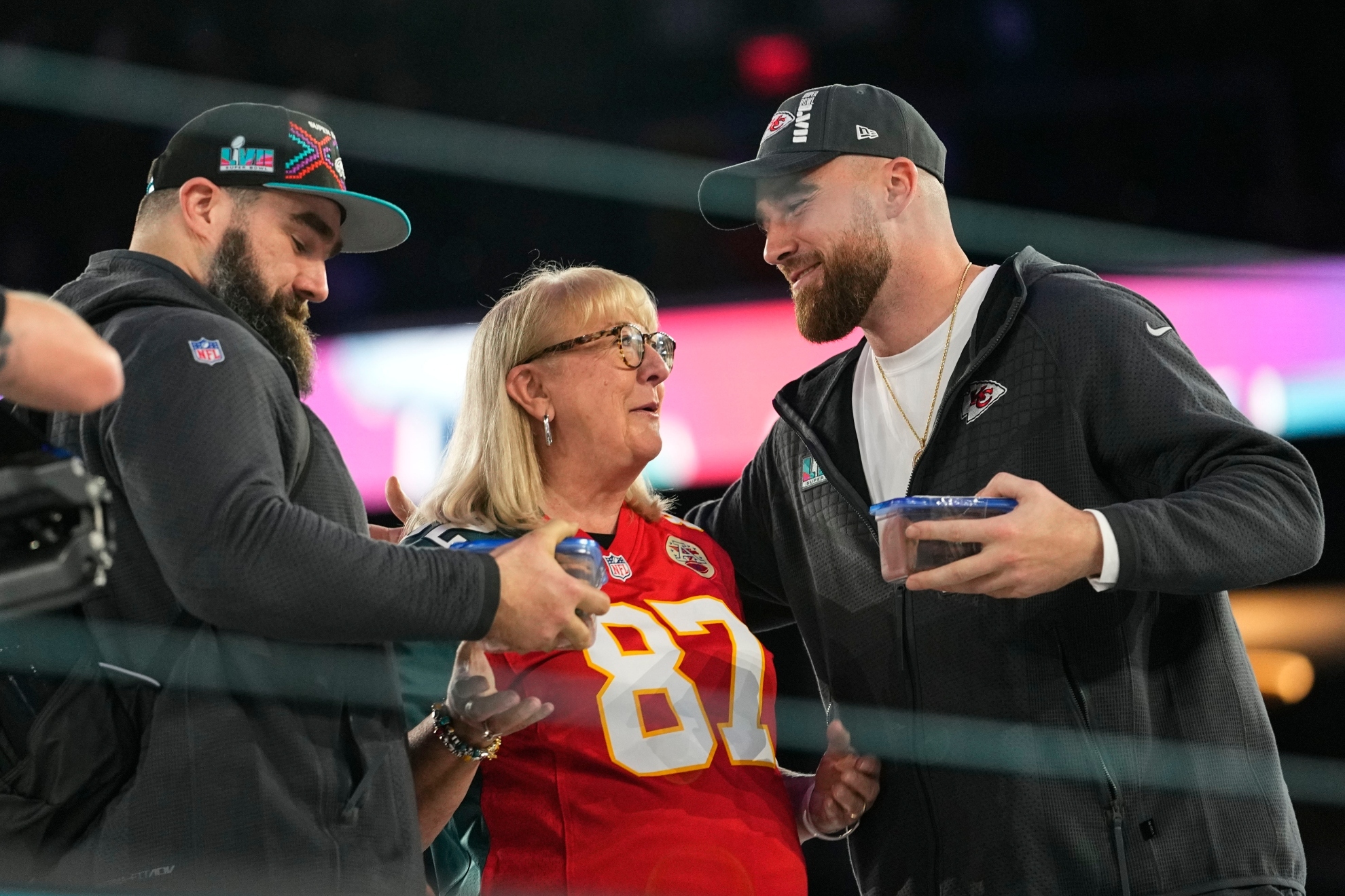 Donna Kelce greets her sons, Philadelphia Eagles center Jason Kelce, left, and Kansas City Chiefs tight end Travis Kelce during the NFL football Super Bowl 57 opening night, Monday, Feb. 6, 2023, in Phoenix. The Kansas City Chiefs will play the Philadelphia Eagles on Sunday.