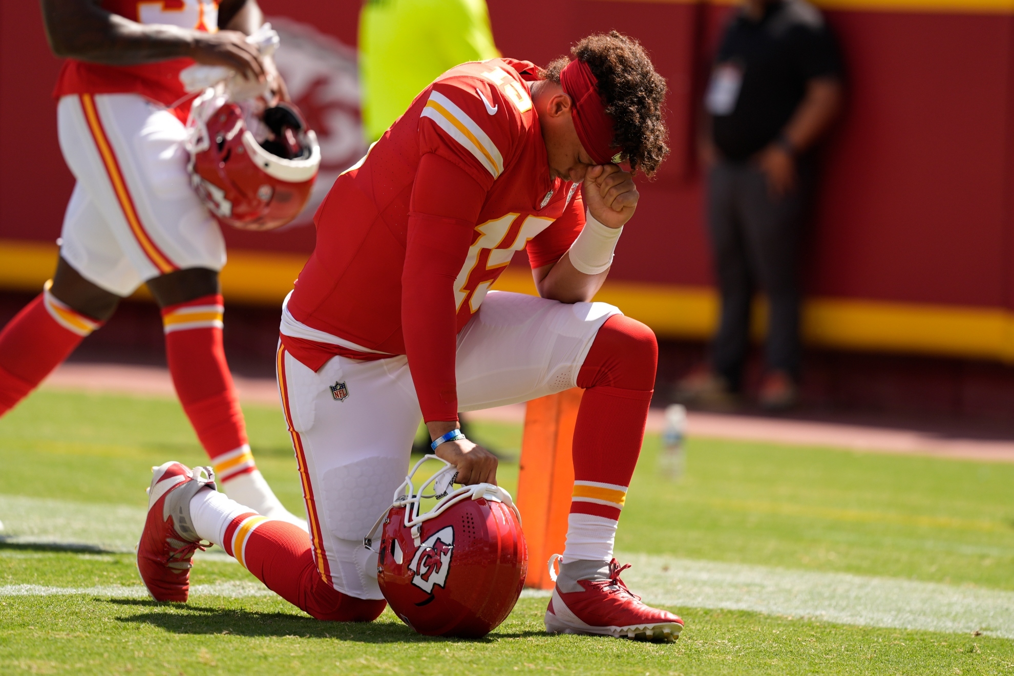 Kansas City Chiefs quarterback Patrick Mahomes (15) kneels before an NFL preseason football game against the Detroit Lions Saturday, Aug. 17, 2024, in Kansas City, Mo.