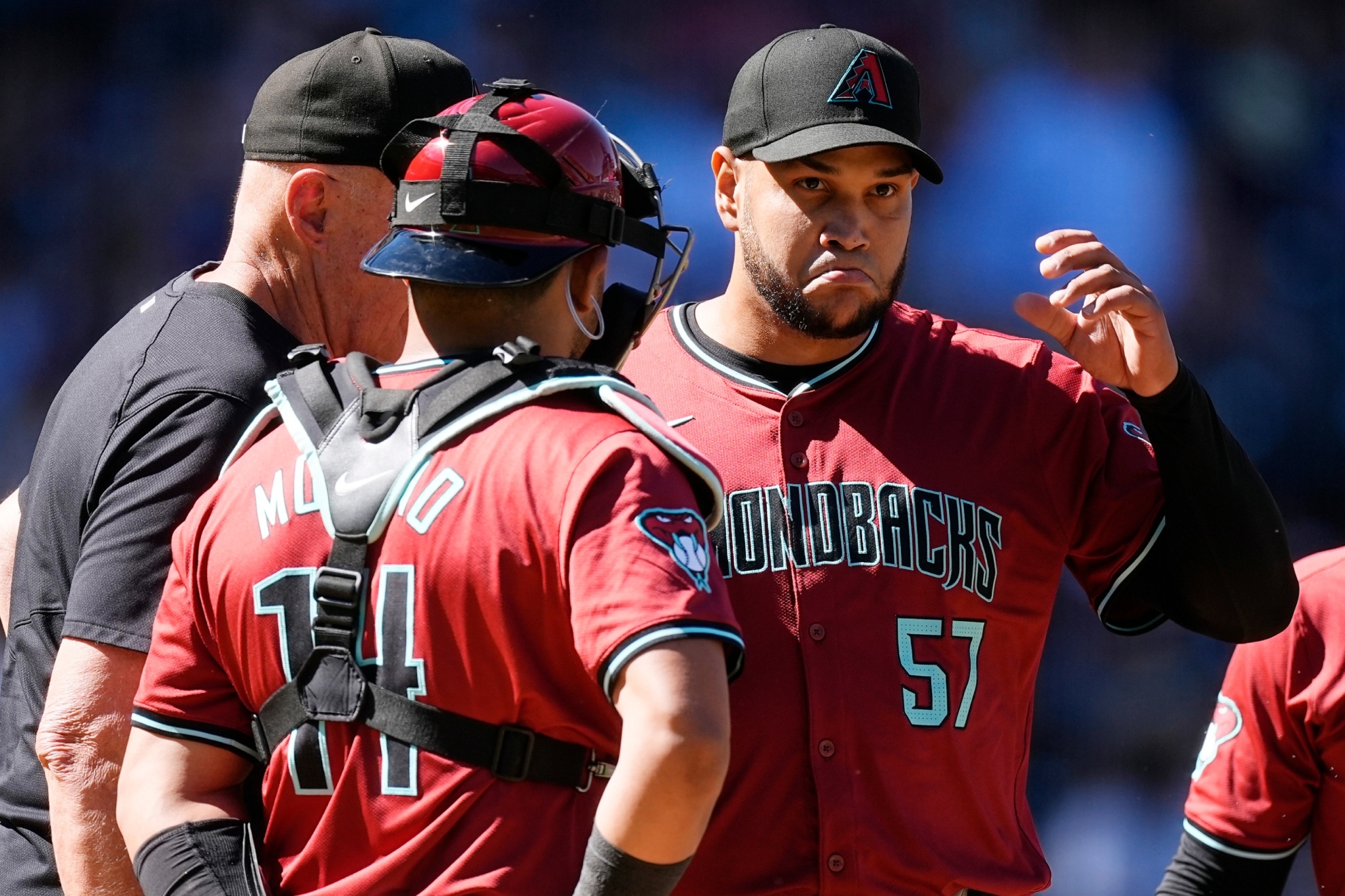 Brent Strom, back left, and catcher Gabriel Moreno, front left, talk with starting pitcher Eduardo Rodriguez.