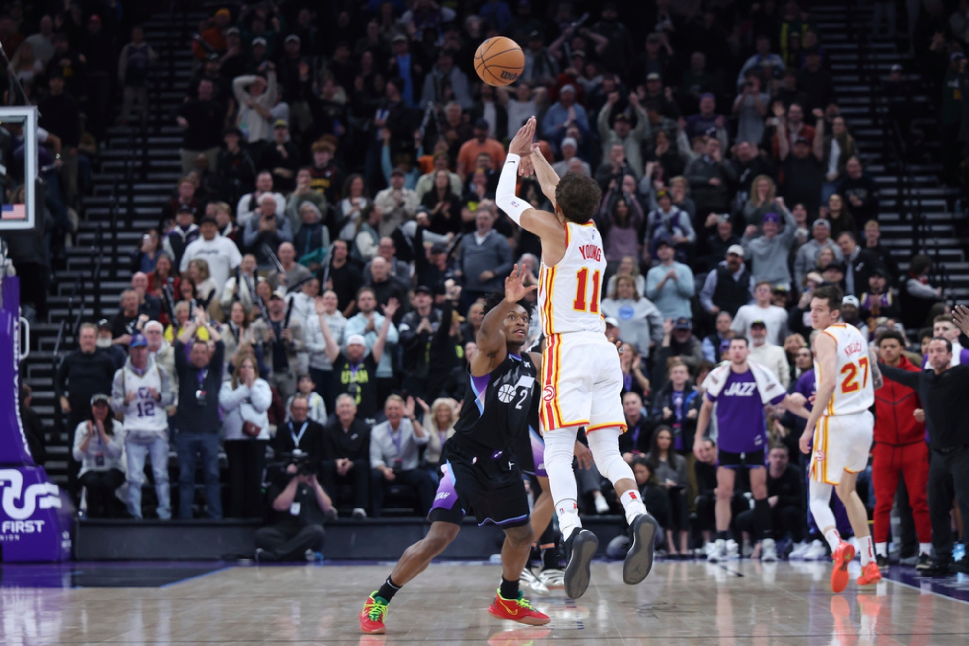 Atlanta Hawks guard Trae Young (11) shoots a three point shot from half court over Utah Jazz guard Collin Sexton (2) at the buzzer to win an NBA basketball game.