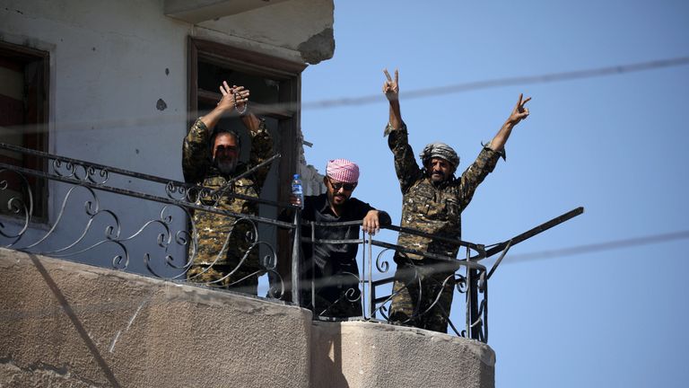 Fighters of Syrian Democratic Forces gesture the "V" sign at the frontline in Raqqa