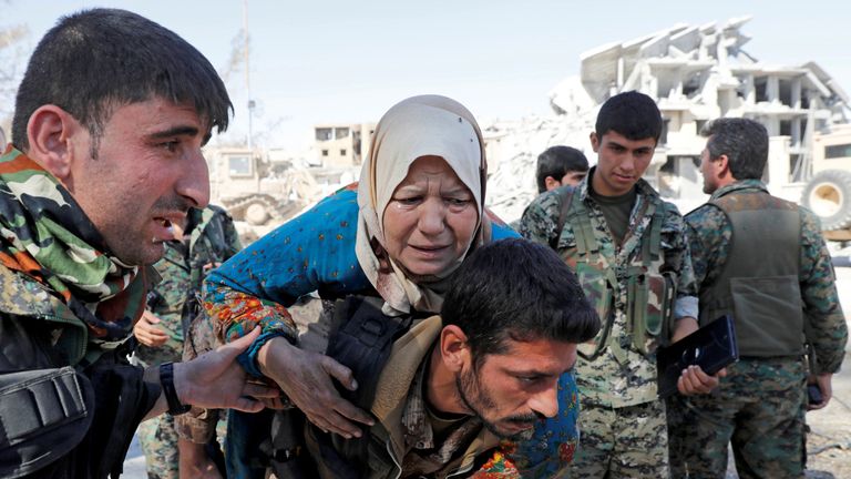 SDF fighters evacuate a civilian from the stadium after Raqqa was liberated from the Islamic State militants