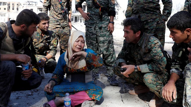 A woman cries after she was rescued by fighters of Syrian Democratic Forces at the stadium