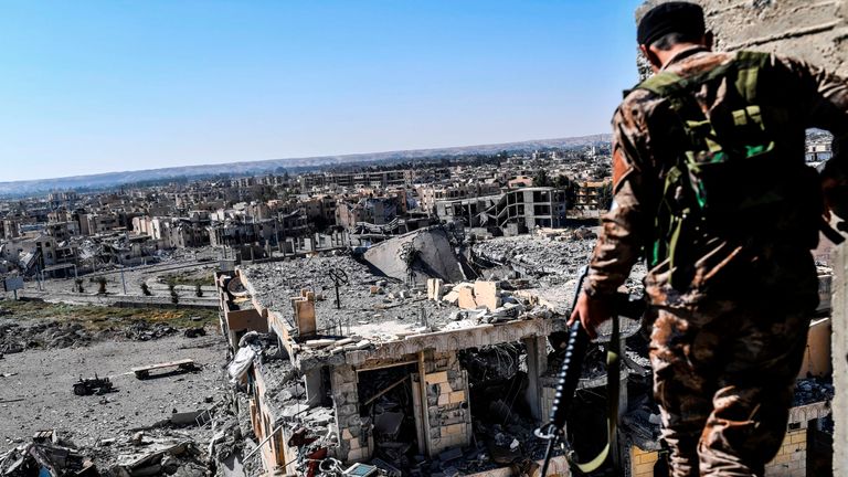 An SDF fighter walks on a building near Raqqa's stadium as they clear the last positions on the frontline