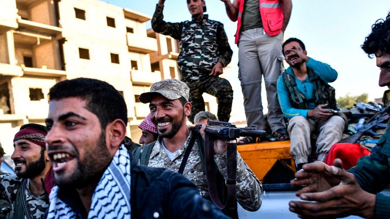 Members of the Syrian Democratic Forces (SDF), backed by US special forces, celebrate at the frontline 