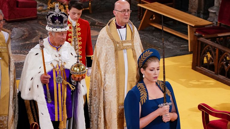 Lord President of the Council, Penny Mordaunt, holds the Sword of State walking ahead of King Charles III during his coronation ceremony in Westminster Abbey, London, Saturday May 6, 2023. (Yui Mok, Pool via AP)