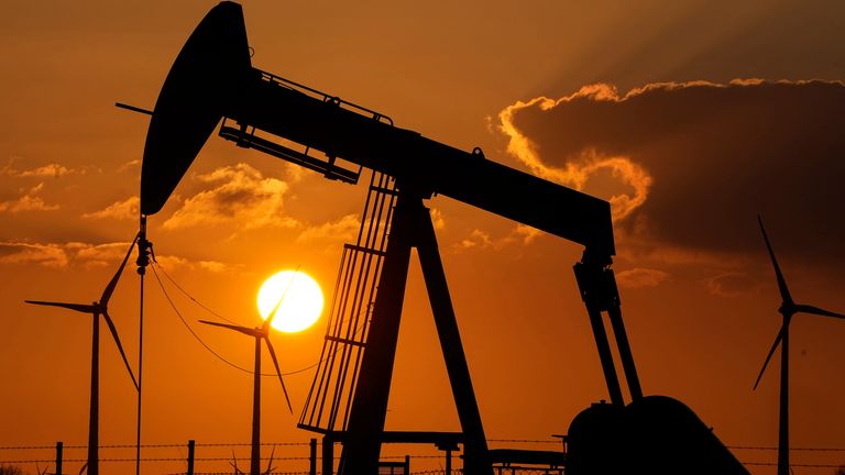 FILE - A pump jack extracts crude oil at an oil field near wind turbines in Emlichheim, Germany, March 18, 2022. Most major countries are finding it easier to promise to fight climate change than actually do it. Experts tracking action to reduce carbon emissions say of the major economies only the European Union is close to doing what's necessary to limit global warming to a few more tenths of a degree. (AP Photo/Martin Meissner, File)