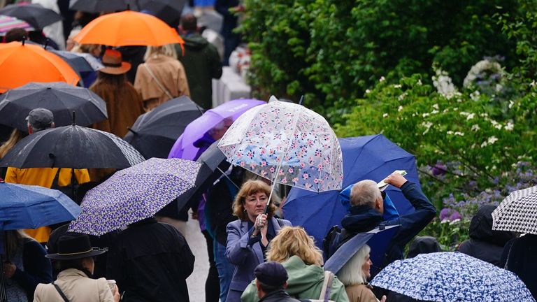 Members of the public shelter under umbrellas the RHS Chelsea Flower Show .
Pic PA
