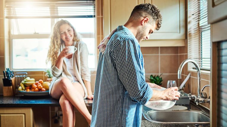 A man washes up while his partner watches on. Pic: iStock