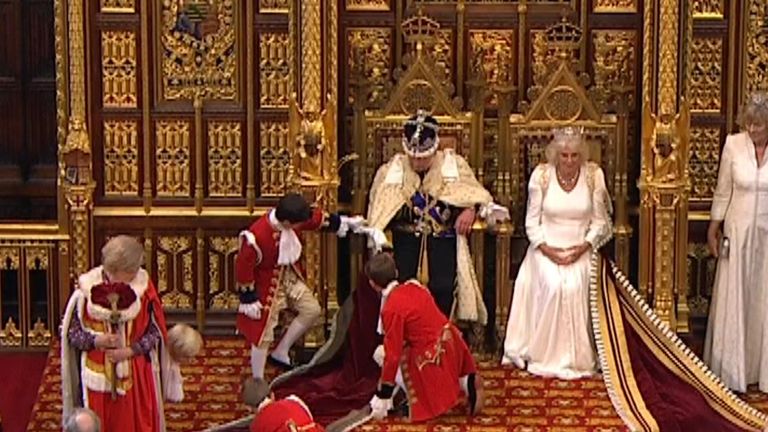 Moment page boy adjusts King’s robe