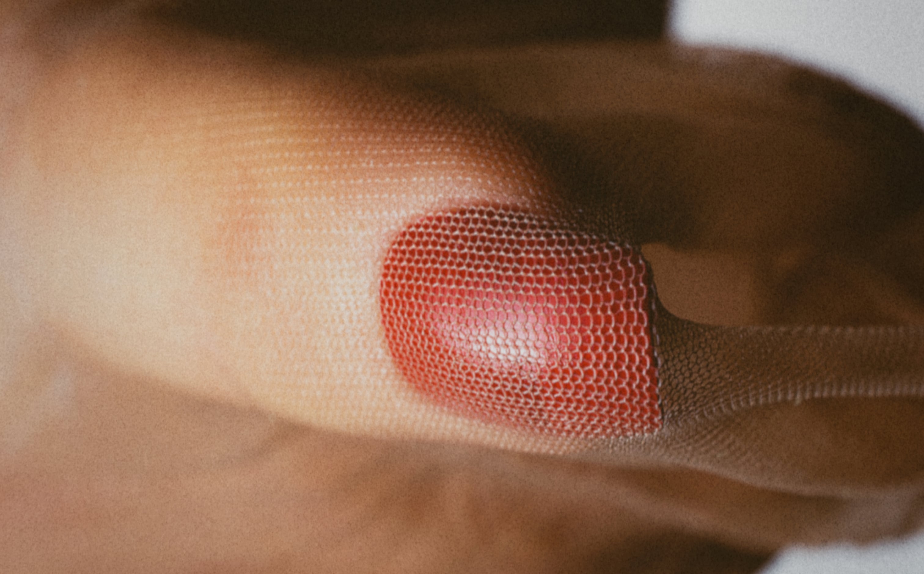 Red-painted fingernail in mesh