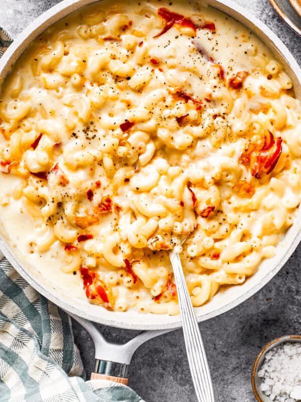 A skillet with mac and cheese and bacon stirred in.