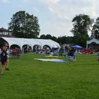 <p>Somers&#x27; Darien Berisha throws to father Adam Berisha as families find their seats for fireworks at the Taste of Somers Food Festival Saturday night</p>