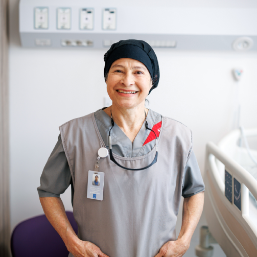 A woman in a hospital gown, waiting for medical attention in a healthcare facility