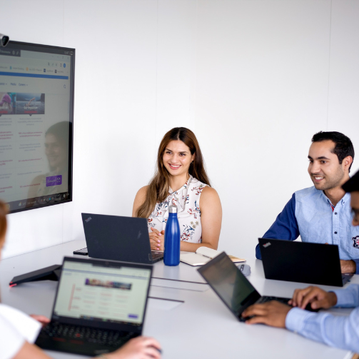 A group of people on their laptops in a meeting room