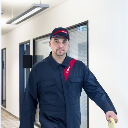 A man in a blue uniform standing confidently, ready for duty