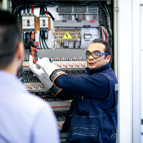 A man wearing goggles doing electrical work.