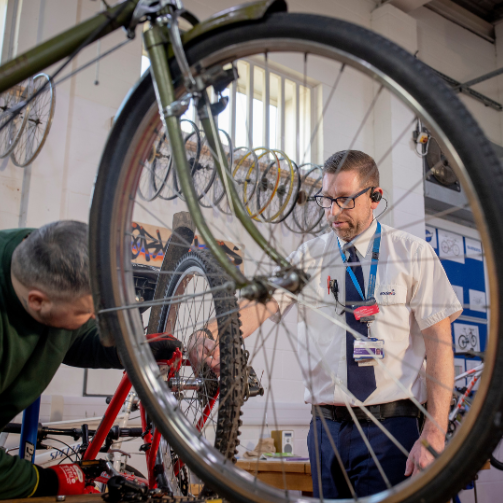 A man diligently repairing a bicycle, focusing on the intricate details of the bike's components. 