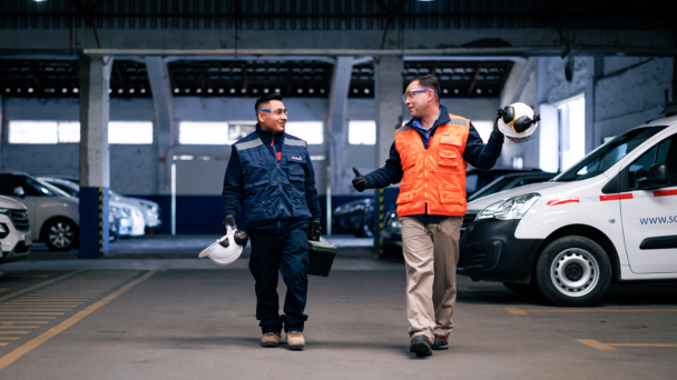 Two men walking in a parking lot.