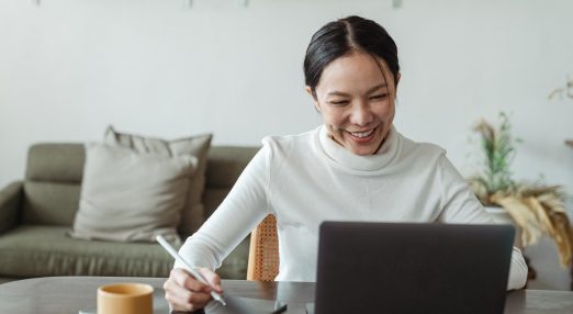 Woman working at home and making video call on laptop