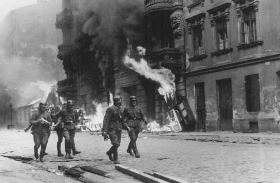 German soldiers burn residential buildings to the ground, one by one, during the Warsaw ghetto uprising.