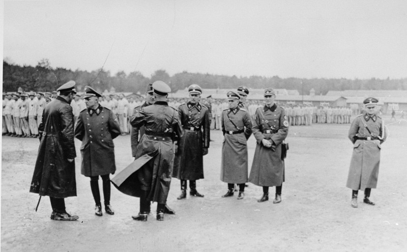 Members of the SS and police speak among themselves during a roll call at the Buchenwald concentration camp.