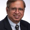 A headshot of Krishan Sabnani in a black suit and a tie.