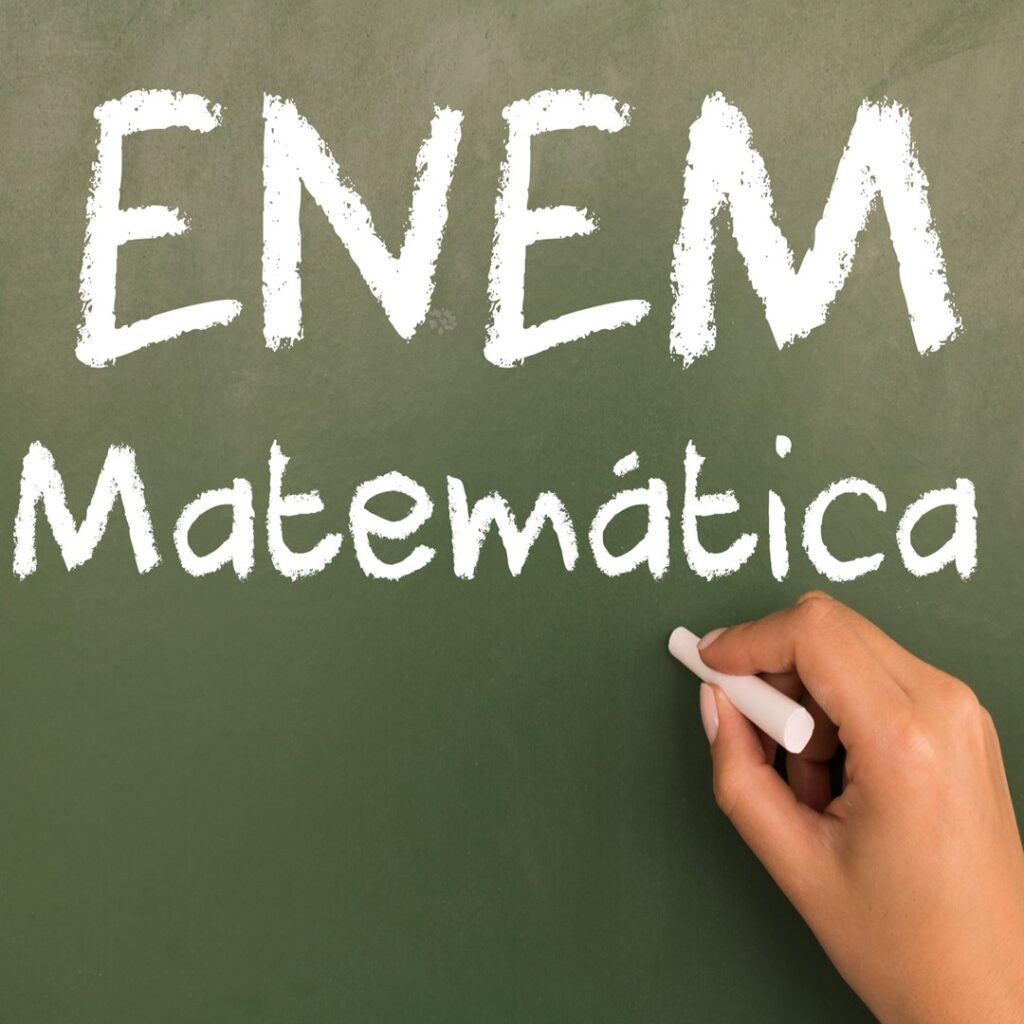 Quadro verde com a inscrição 'ENEM Matemática' destacando tópicos sobre o que mais cai em matemática no Enem, com uma mão segurando giz.