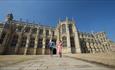 Windsor Castle Chapel. A couple holding hands and walking in front of the Chapel.