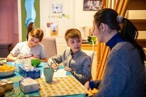 a mother doing homework with her two children