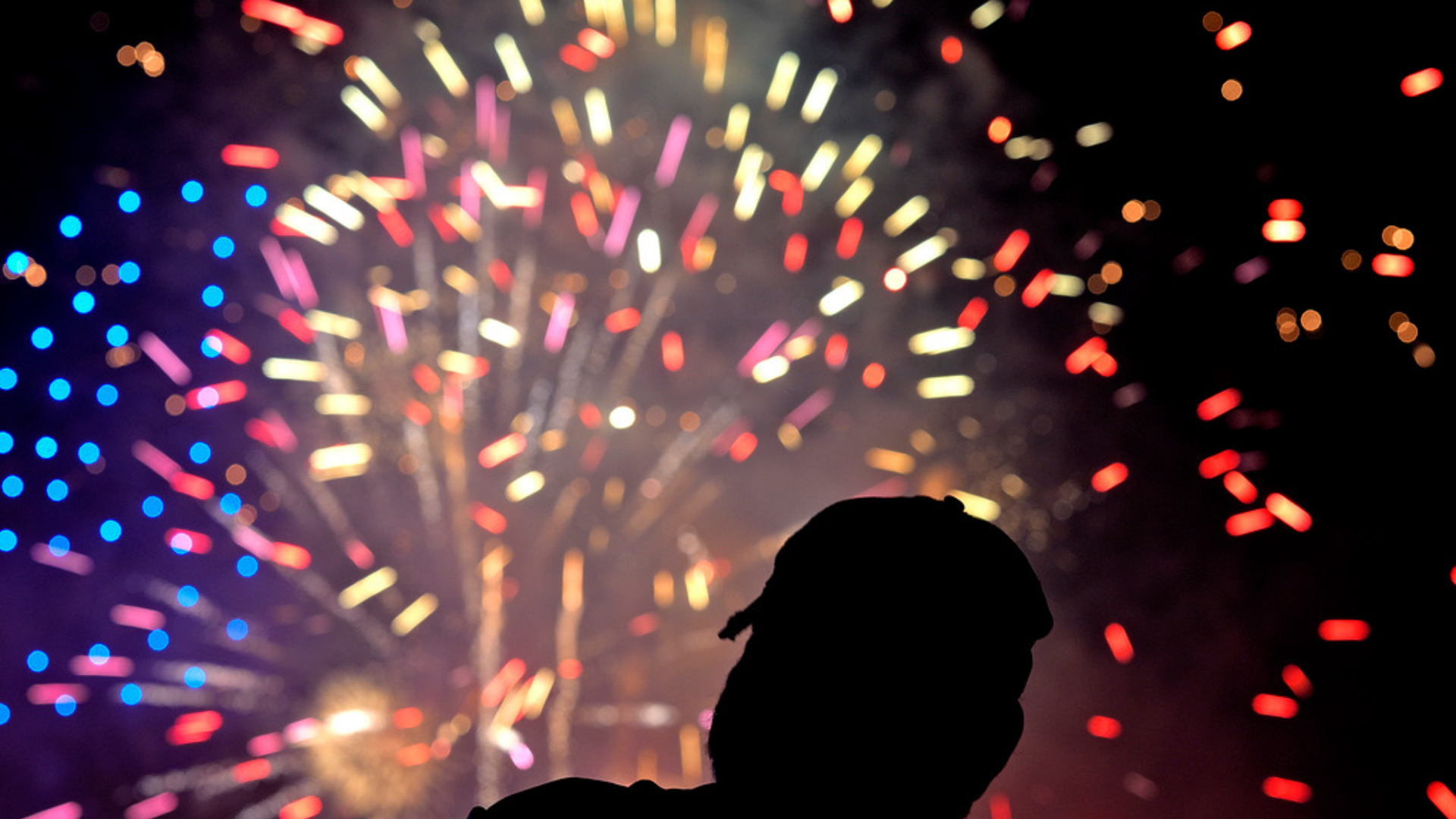 A fan watches a Fourth of July fireworks display after a baseball game