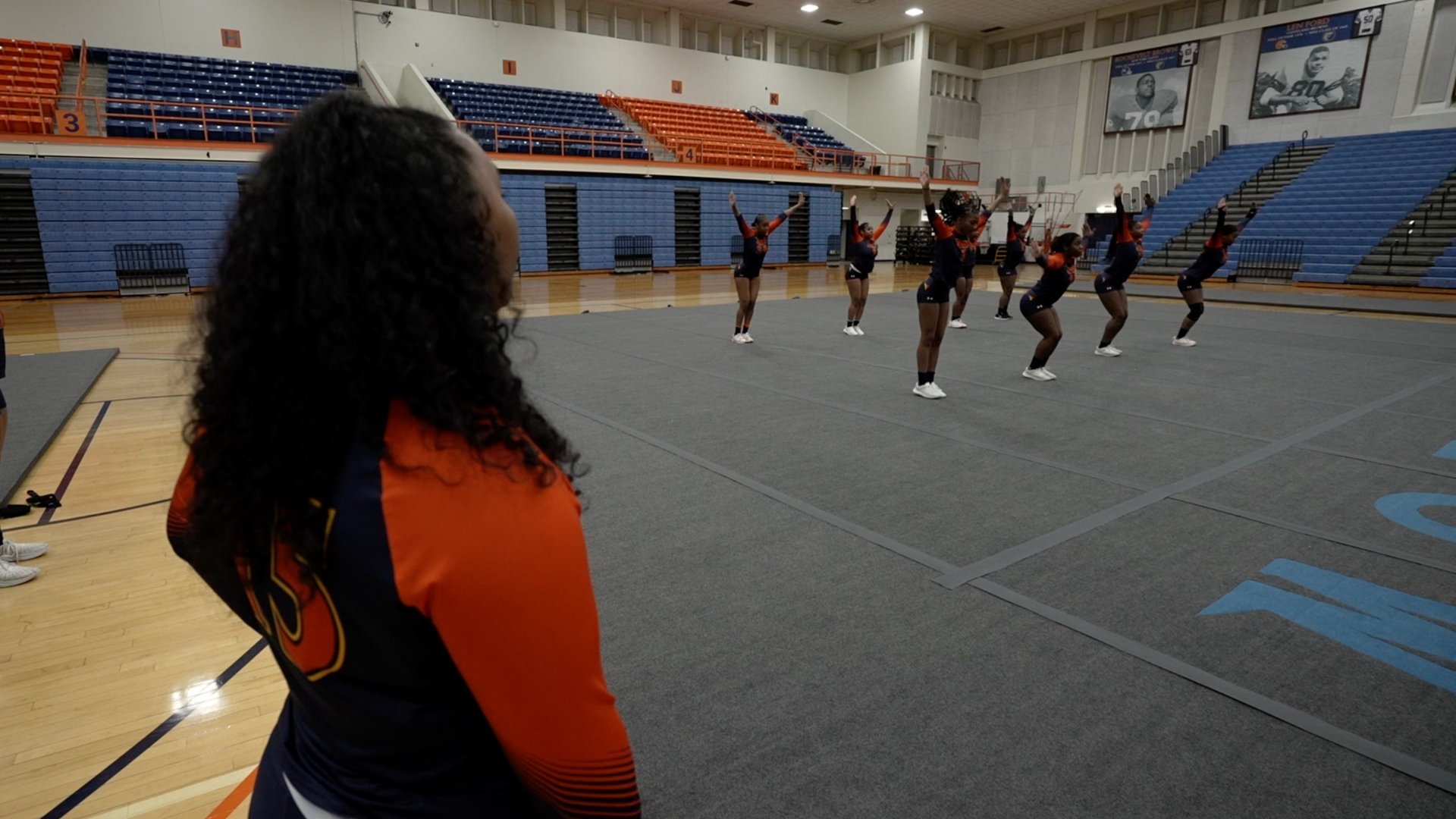 Some of the girls from the team practicing on the mat in the gym