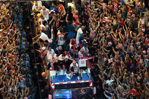 TOPSHOT - Croatian national football team players ride a bus as people gather for a 'heroes' welcome' in tribute to their national team, after reaching the final at the Russia 2018 World Cup, at the Bana Jelacica Square in Zagreb on July 16, 2018. / AFP PHOTO / Denis Lovrovic ORG XMIT: DLO014