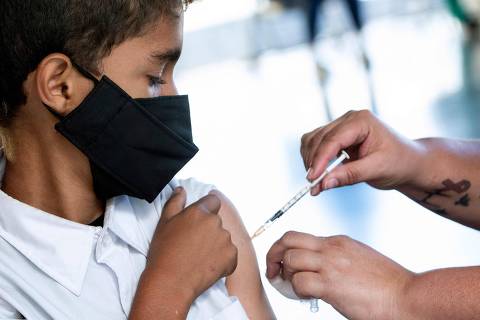 A boy reacts while getting a dose of the Pfizer-BioNTech vaccine against Covid-19, at a vaccination post inside the Children's Museum, in San Jose, Costa Rica, on January 12, 2022. (Photo by Ezequiel BECERRA / AFP) ORG XMIT: CRC005