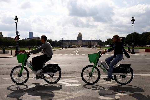 Women ride electric Lime bicycles on a bike path past the Hotel des Invalides in Paris, France, September 23, 2024. REUTERS/Abdul Saboor ORG XMIT: GGG-ABD02