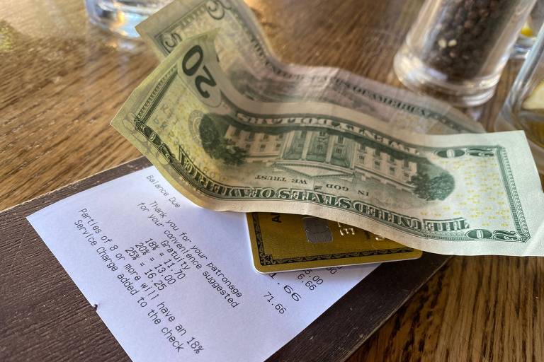 Notas de dólares deixadas na mesa de um restaurante em Los Angeles junto com nota fiscal