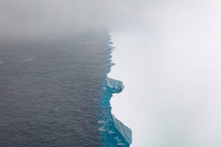 Borda de iceberg vista de cima, ao lado da água do oceano