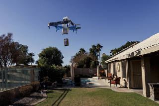 Amazon?s new delivery drone drops a package with an order in the backyard of an AirBnb in Goodyear, Arizona, Dec. 16, 2024.(Adriana Zehbrauskas/The New York Times)