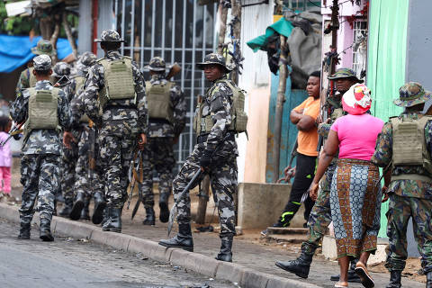 FILE PHOTO: A member of the Mozambique military, looks on as they patrol the streets of the capital a day after a 