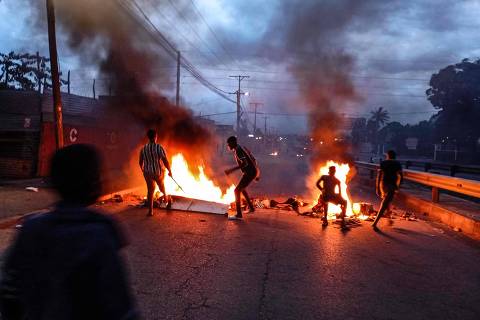 TOPSHOT - Protesters gather next to a burning barricade in Maputo on December 23, 2024. Mozambique's highest court confirmed Monday the ruling party's victory in a disputed October vote after allegations of rigging triggered weeks of deadly street clashes. Fears are high that more violence could break out in the southern African nation after the opposition threatened to call an uprising following the decision. (Photo by Amilton Neves / AFP)