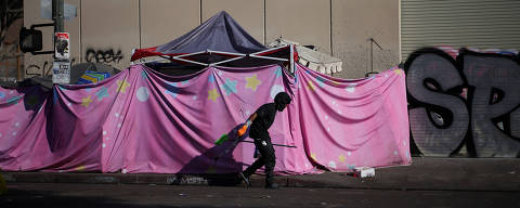 A man walks by a tent encampment in Skid Row, Los Angeles, California, U.S., December 9, 2024. REUTERS/Daniel Cole ORG XMIT: HFS-DCO124