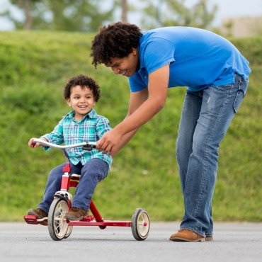 father with son on a tricycle