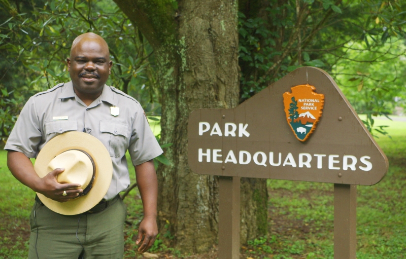 Superintendent Cassius Cash stands next to the park headquarters sign