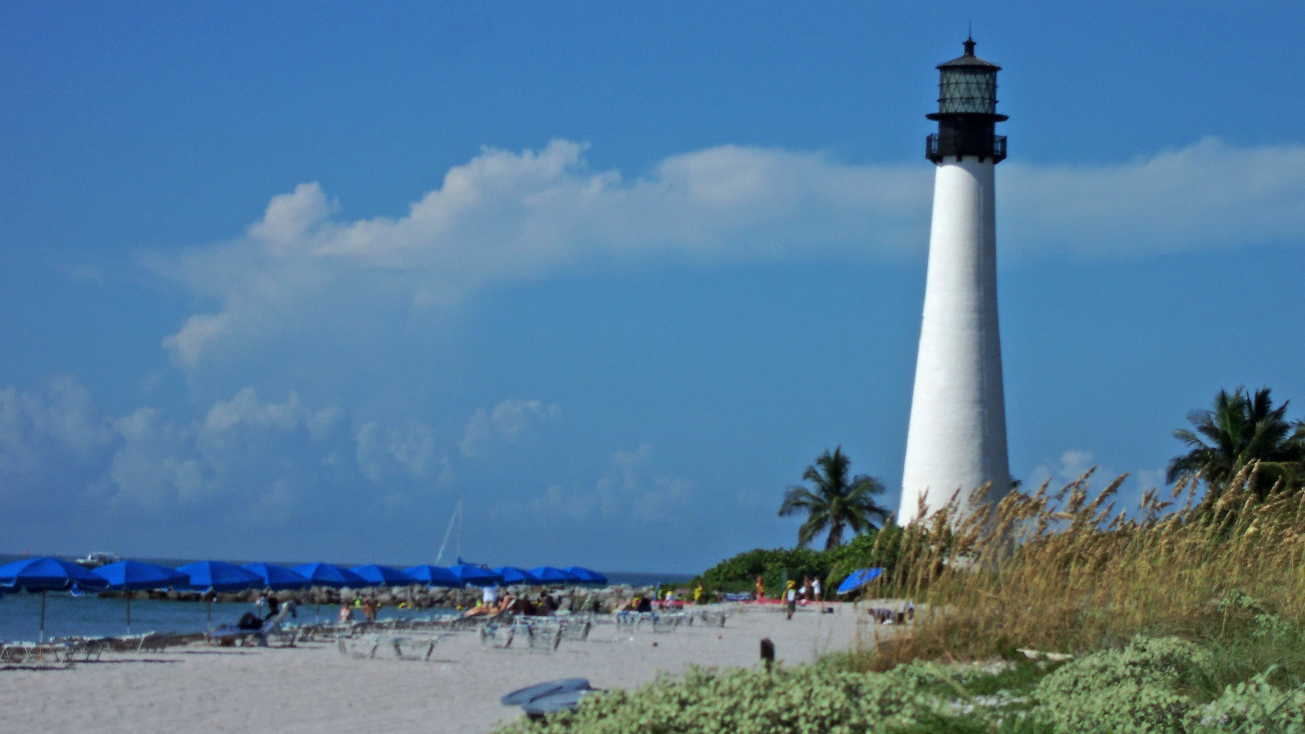 Lighthouse and oceanfront with beachgoers