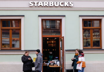 FILE PHOTO: People wait for their orders outside a Starbucks coffee shop which is open only for takeaway due to new measures imposed by local authorities to curb the spread of the coronavirus disease in Mosco