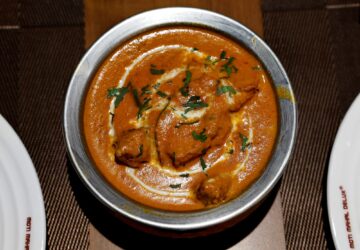 A freshly prepared butter chicken dish is placed on a table inside the Moti Mahal Delux restaurant in New Delhi, India, January 23, 2024. REUTERS/Sahiba Chawdhary