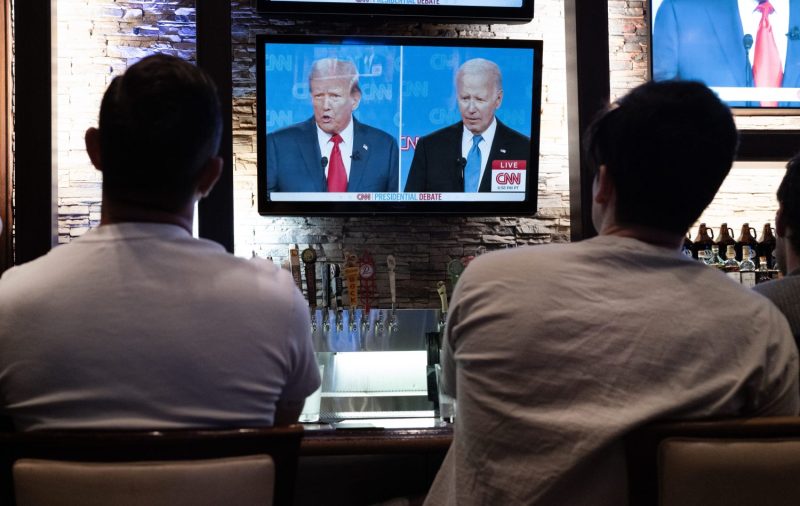 People watch a live television debate between U.S. President Joe Biden and former President Donald Trump.