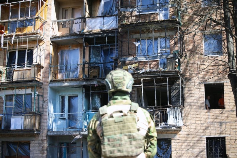 A local volunteer looks at a building damaged by Ukrainian strikes in Kursk on August 16, 2024, following Ukraine's offensive into Russia's western Kursk region.